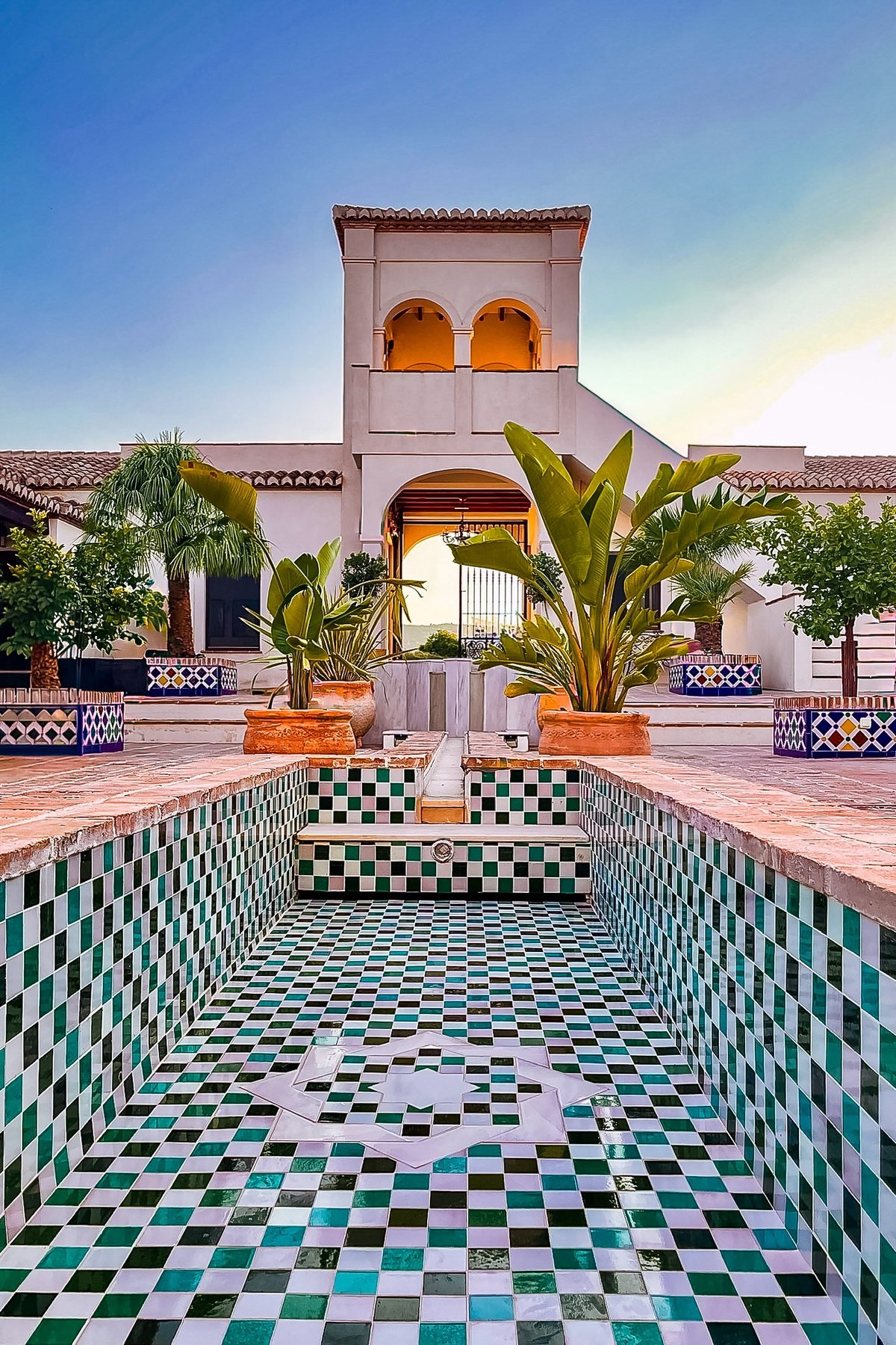 Patio de estilo colonial con fuente y vegetación, evocando los jardines del Centro Veracruzano