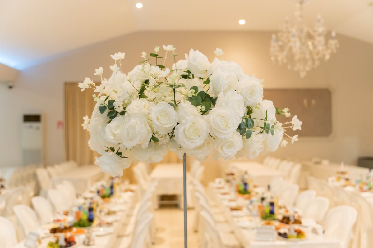 Salón de eventos con mesas preparadas y arreglos florales, evocando el Centro de Espectáculos