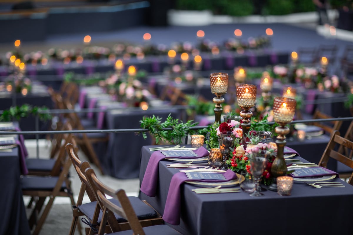 Recepción al aire libre con velas y luces entre árboles, evocando los jardines del Centro
